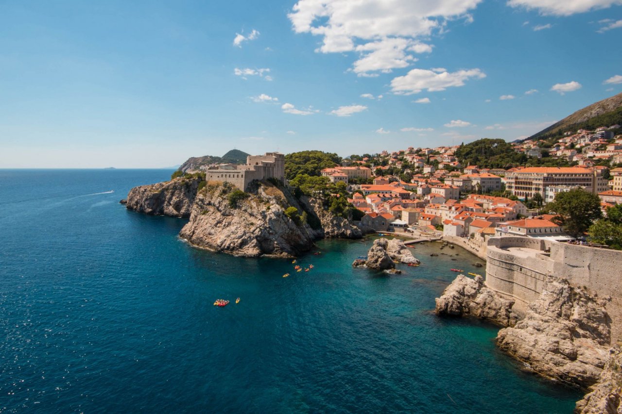 A photo from the sea wall of Dubrovnik, Croatia showing the clear and deep blue sea and amazing cliff formations